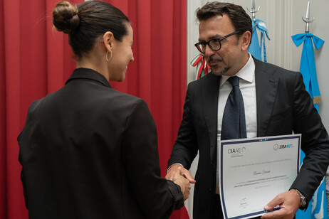 El embajador Lucentini entregando uno de los diplomas.