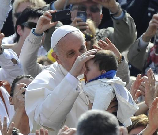 Papa Francesco accarezza un bimbo durante l'udienza generale in Piazza San Pietro