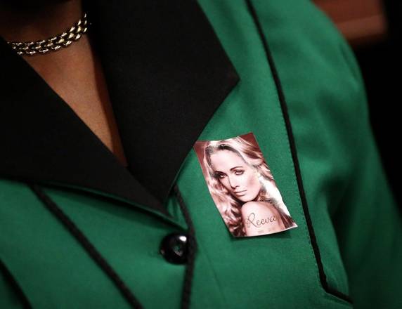 Un donna indossa una spilla con la foto di Reeva Steenkamp