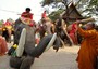 Monaco buddista thailandese getta acqua santa per benedire gli elefanti e i loro conducenti