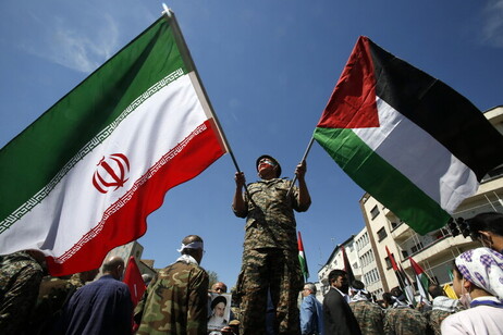 Un iraní ondea las banderas de Irán y de Palestina.