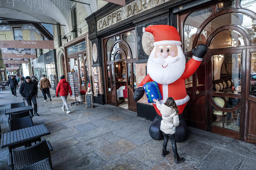Un Santa Claus frente a un bar, en Turín (ANSA)