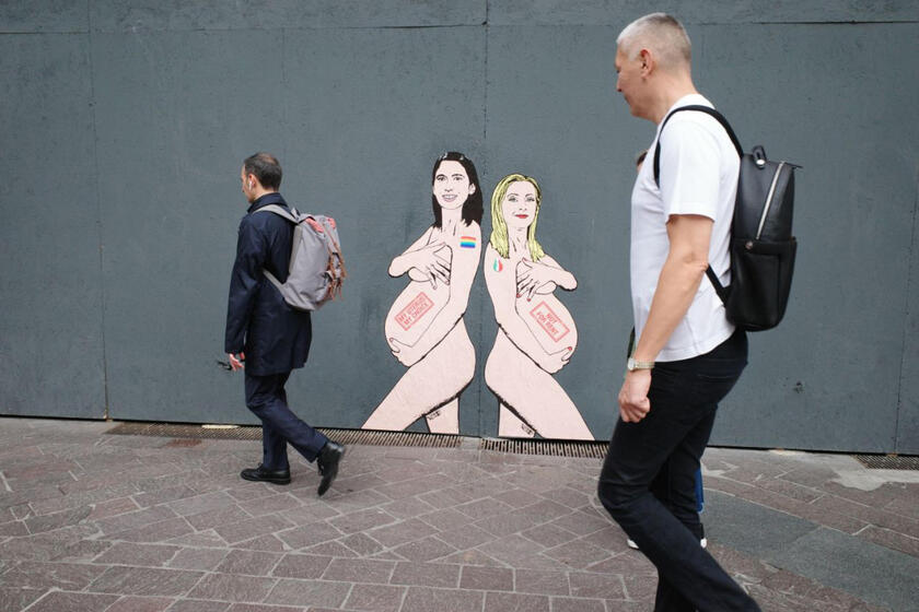 Meloni y Schlein retratadas desnudas y embarazadas sobre mural de Milán