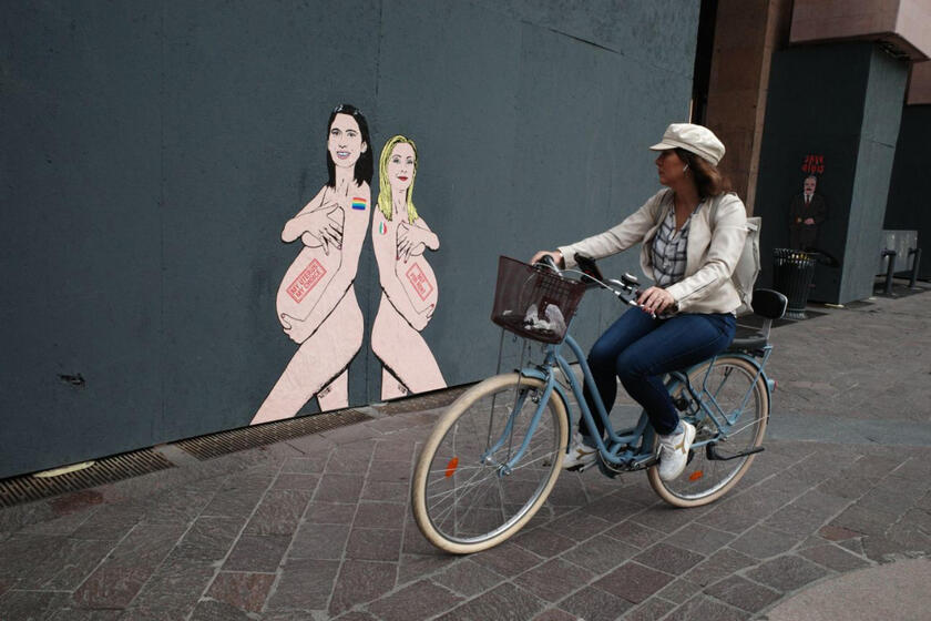 Meloni y Schlein retratadas desnudas y embarazadas sobre mural de Milán