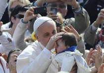 Papa Francesco accarezza un bimbo durante l'udienza generale in Piazza San Pietro